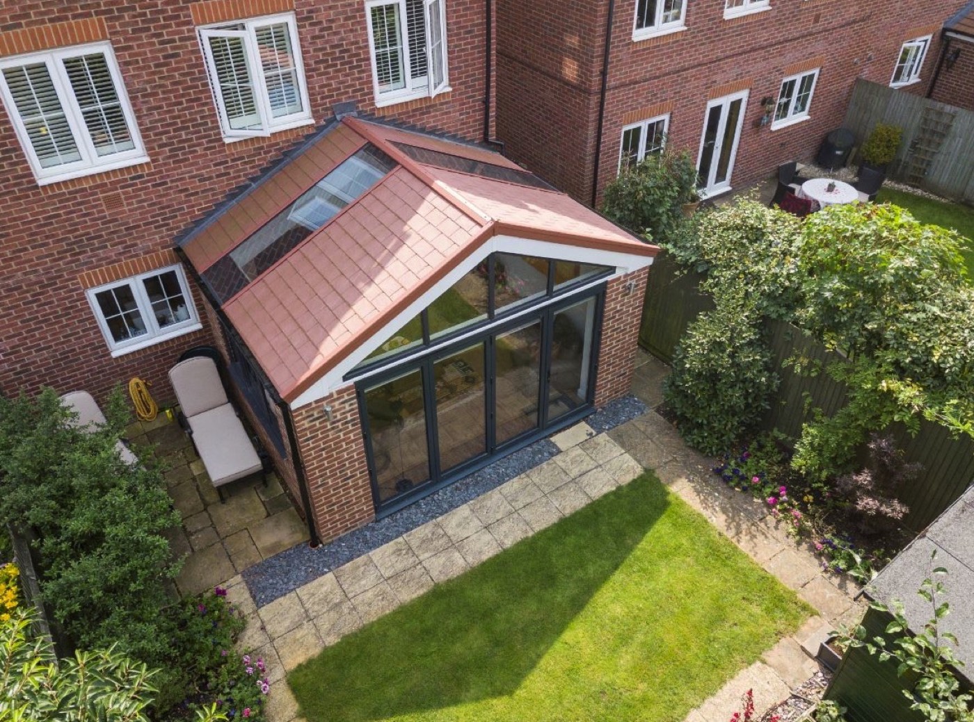 Tiled-roof rear extension with bi-fold doors and glazed roof panels on to a rear garden